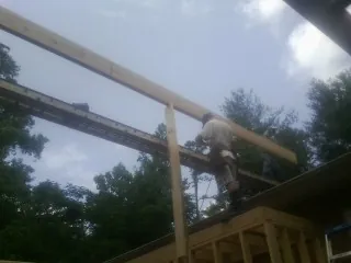 Carpenter setting a ridge beam over a new addition frame — Ice Dam Removal by Roofing Brothers in Rosemount