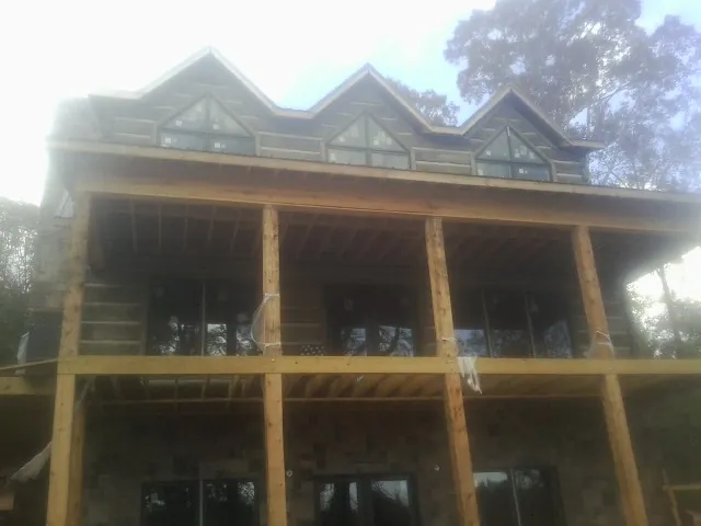 Dormers and porch framing on a large log home under construction — Roof Coating work by our crew in Rosemount
