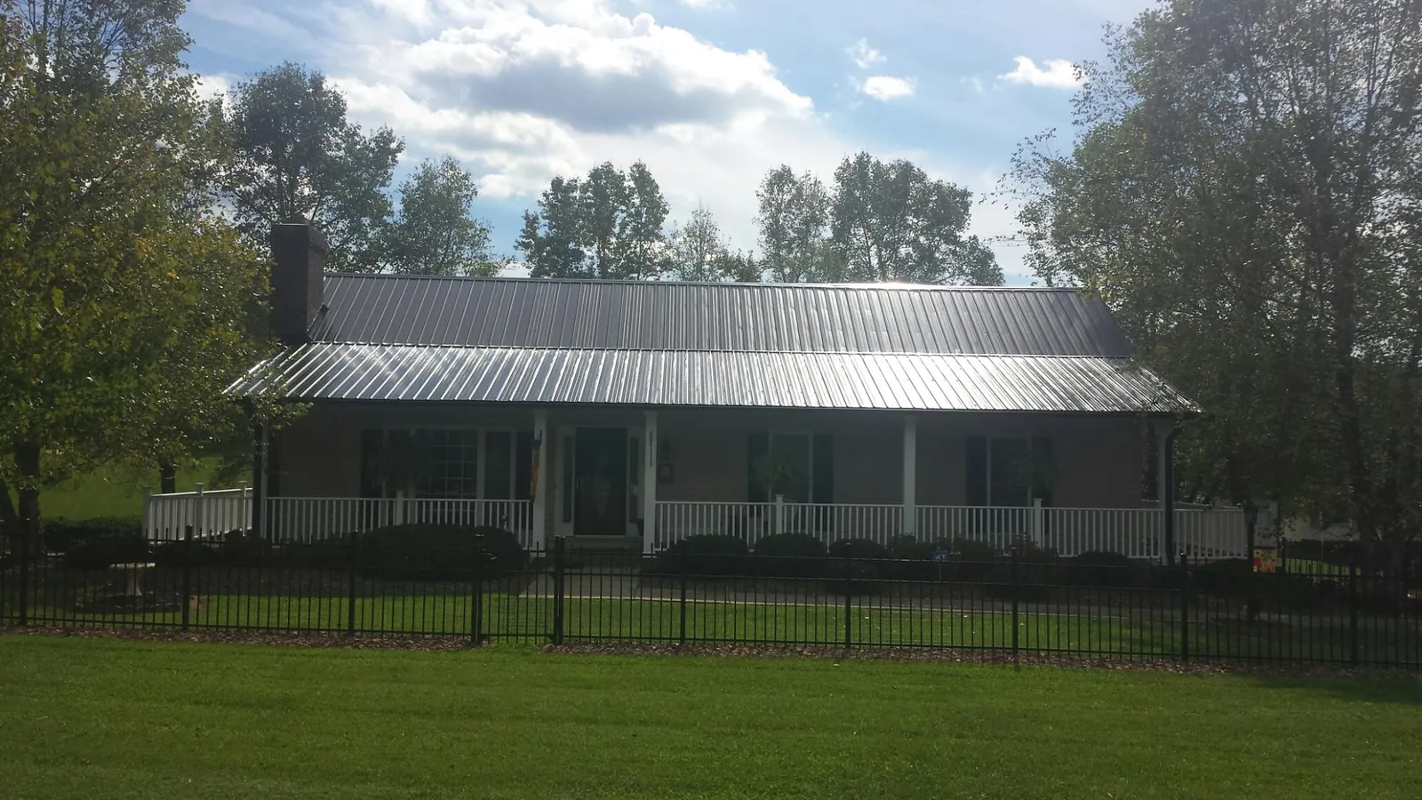Gray metal roof on a brick ranch with a full width front porch — Gutter Guard Installation work by our crew in Rosemount